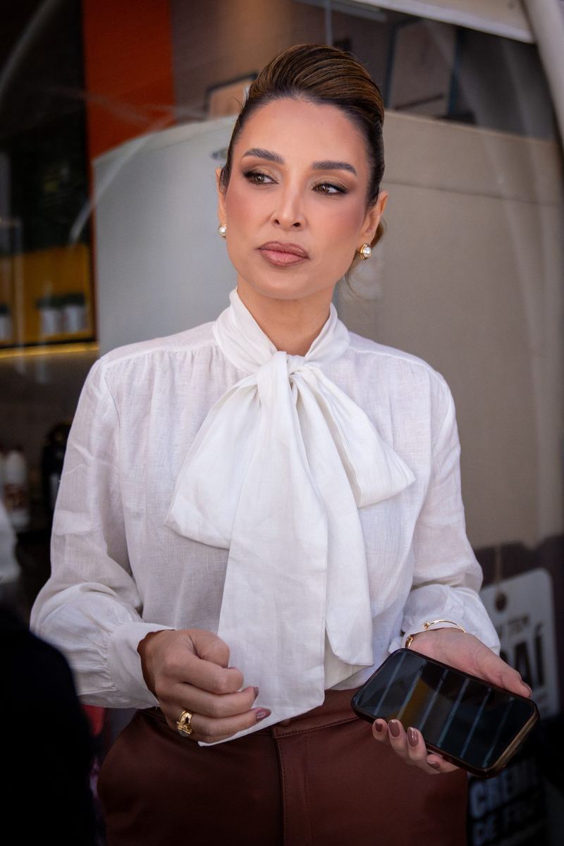 Retrato de mulher de blusa branca com laço e coque, olhando para o lado